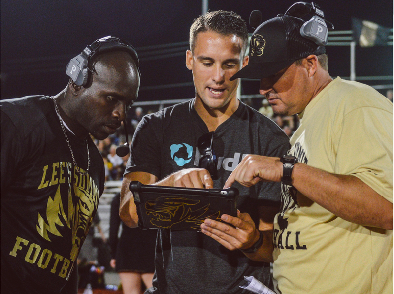 Football coaches discuss tactics with tablet