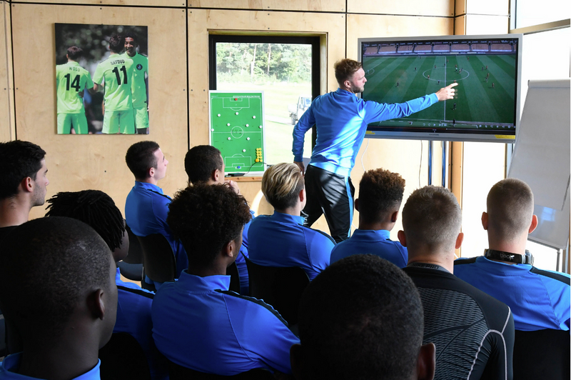 El entrenador analiza tácticas de partidos de fútbol con el equipo