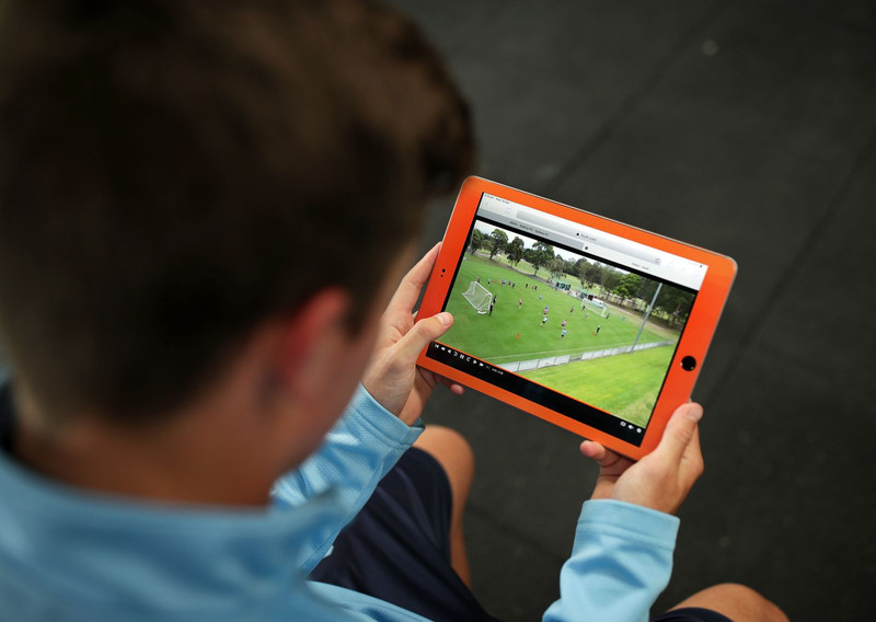 Un hombre ve una grabación de fútbol en una tableta