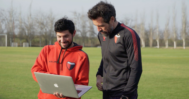 Bruno Oliveto y Eduardo Domínguez repasan la grabación del video desde el campo de entrenamiento de Colón.