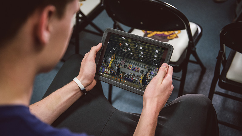 Un hombre ve una grabación de baloncesto en una tableta